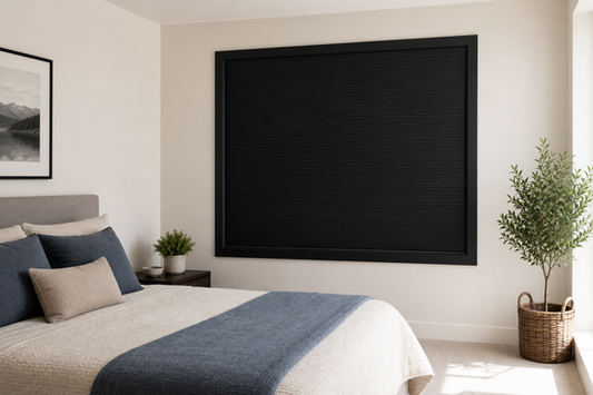 Bright summer bedroom with a fully closed black framed total blackout blind and no visible edge light