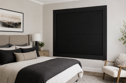 Bedroom with a fully closed black framed blackout blind with side tracks and no visible edge light